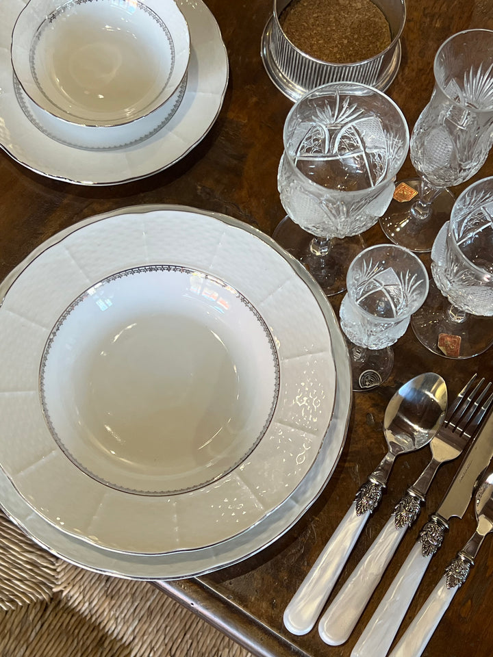 Elegante Servizio di piatti in porcellana Thun Czechoslovakia decorato con dettagli raffinati nei toni dell'argento e decoro a filigrana sul bordo che richiamo lo stile classico. E' composto da piatto piano, fondo, piattino da frutta, un vassoio tondo e uno ovale, una zuppiera, quattro ciotole, dodici ciotoline, una salsiera e un set per condimento. 
Zuppiera 26x23x16h cm Piatto piano 26 cm Piatto fondo 23 cm Piattino da dolce 19,5 cm Ciotoline 13x3,5 cm Ciotola 24x7cm Salsiera 18x18x6,5h cm Vassoio o