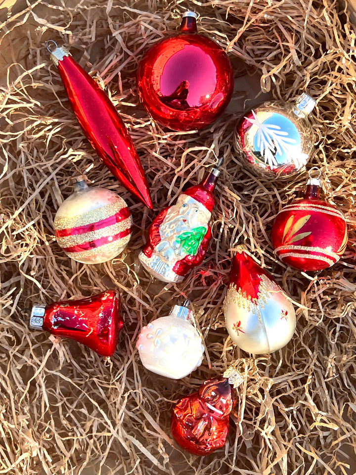 Set di dieci palline in vetro vintage dai toni dell'argento e del rosso. Pezzi unici, piani di storia ed incanto, pronti a brillare sul tuo albero.