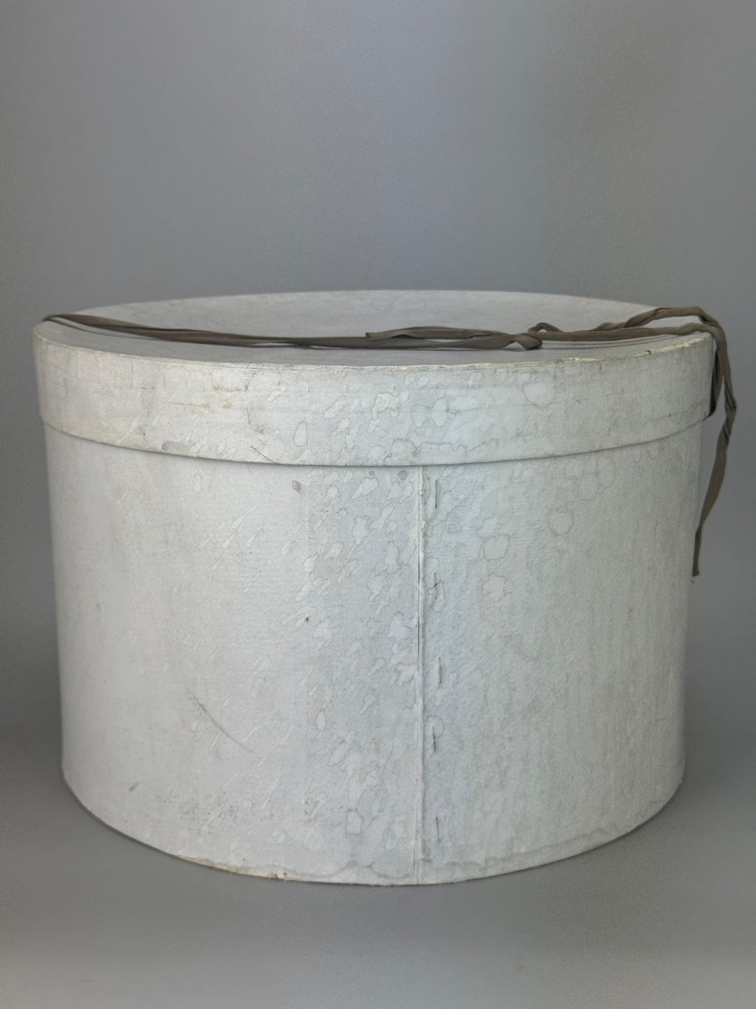 Cappelliera Vintage rotonda in cartone di colore grigio con chiusura a nastro