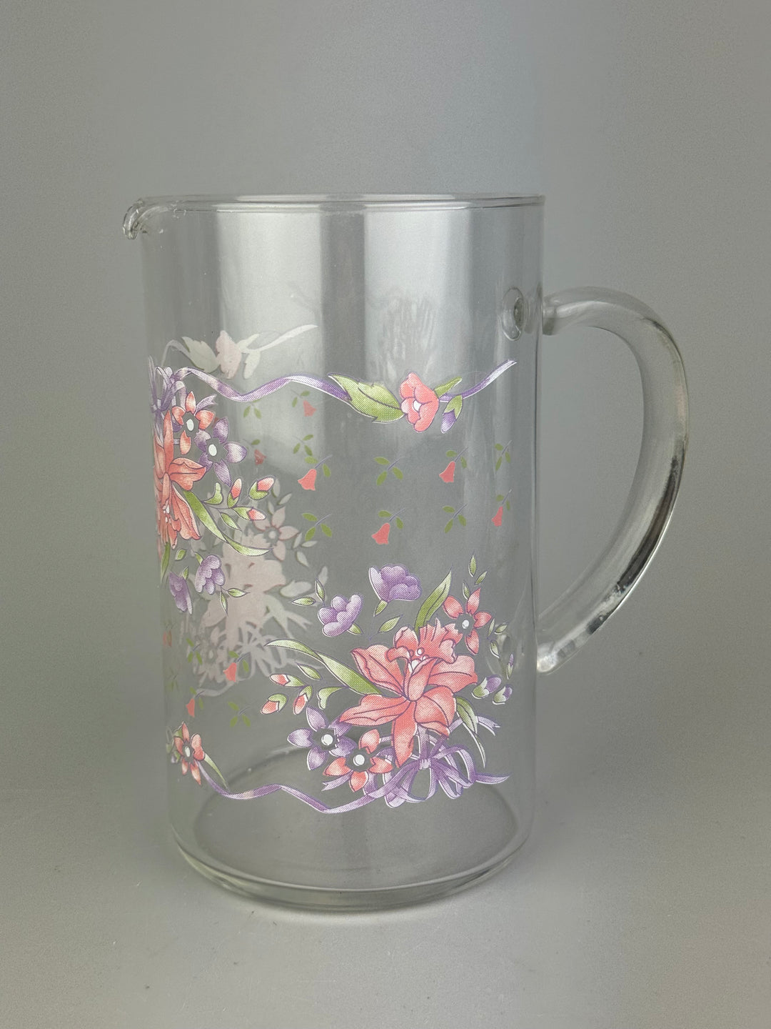 Brocca vintage in vetro trasparente con decorazione floreale rosa e lilla
