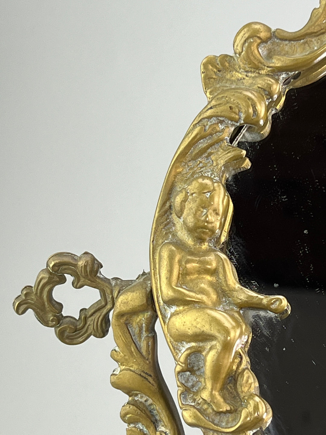 Specchio da tavolo in bronzo dorato con putti stile rococò