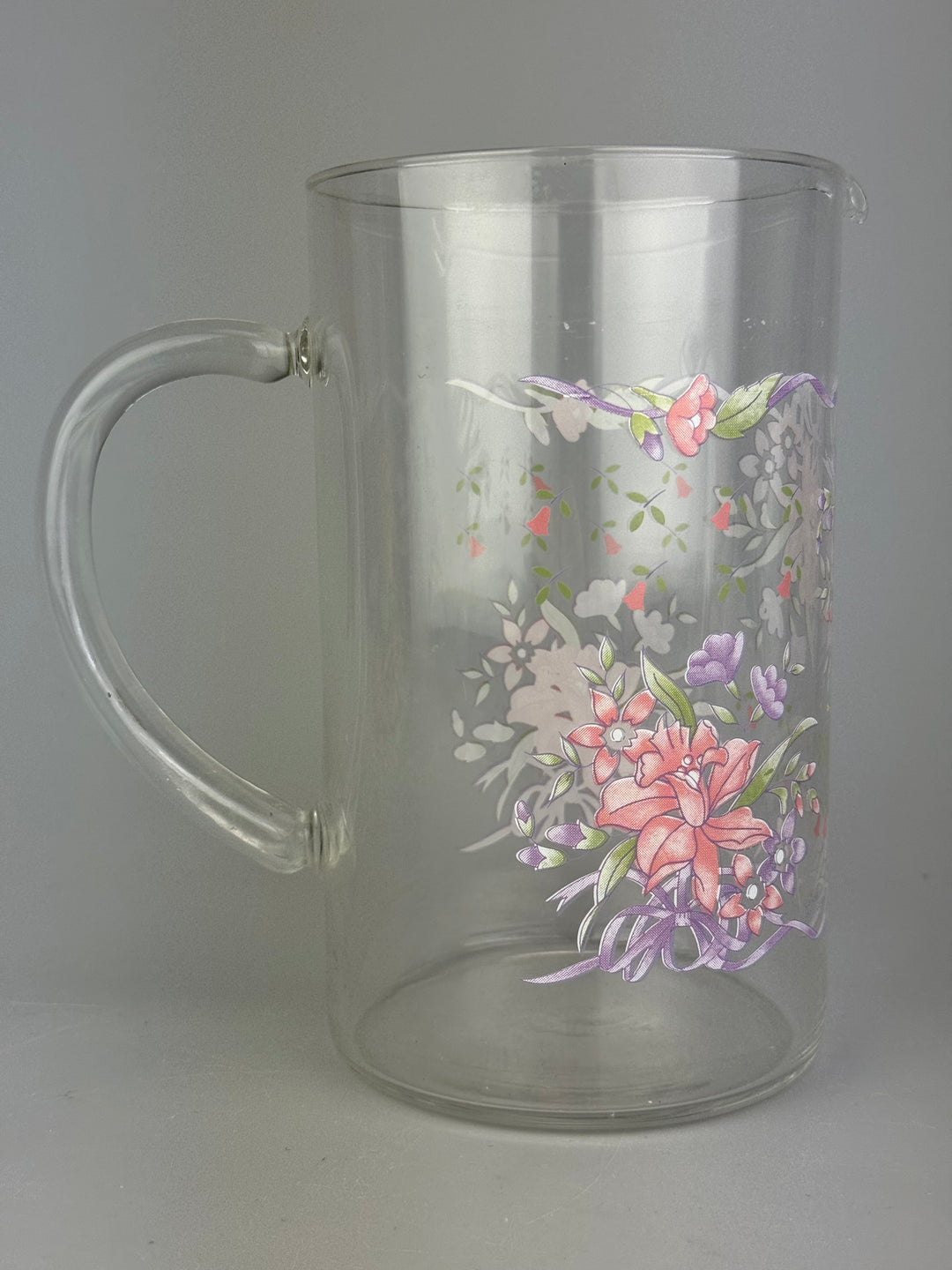 Brocca vintage in vetro trasparente con decorazione floreale rosa e lilla