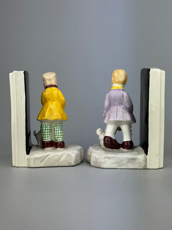 Coppia di fermalibri vintage in porcellana dipinta con bambini e cagnolini metà XX secolo
