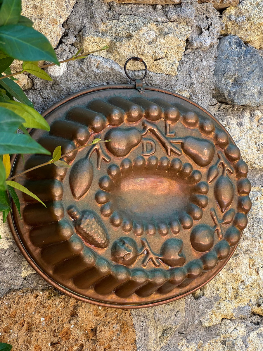 Antico stampo ovale da budino in rame sbalzato con decorazione a rilievo raffigurante frutta.