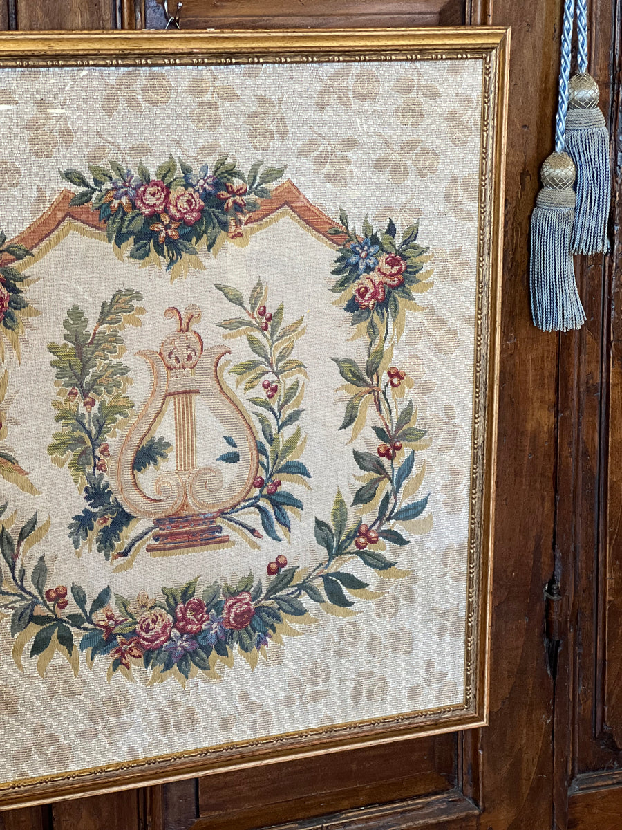 Arazzo decorativo con lira centrale e ghirlanda floreale in cornice dorata