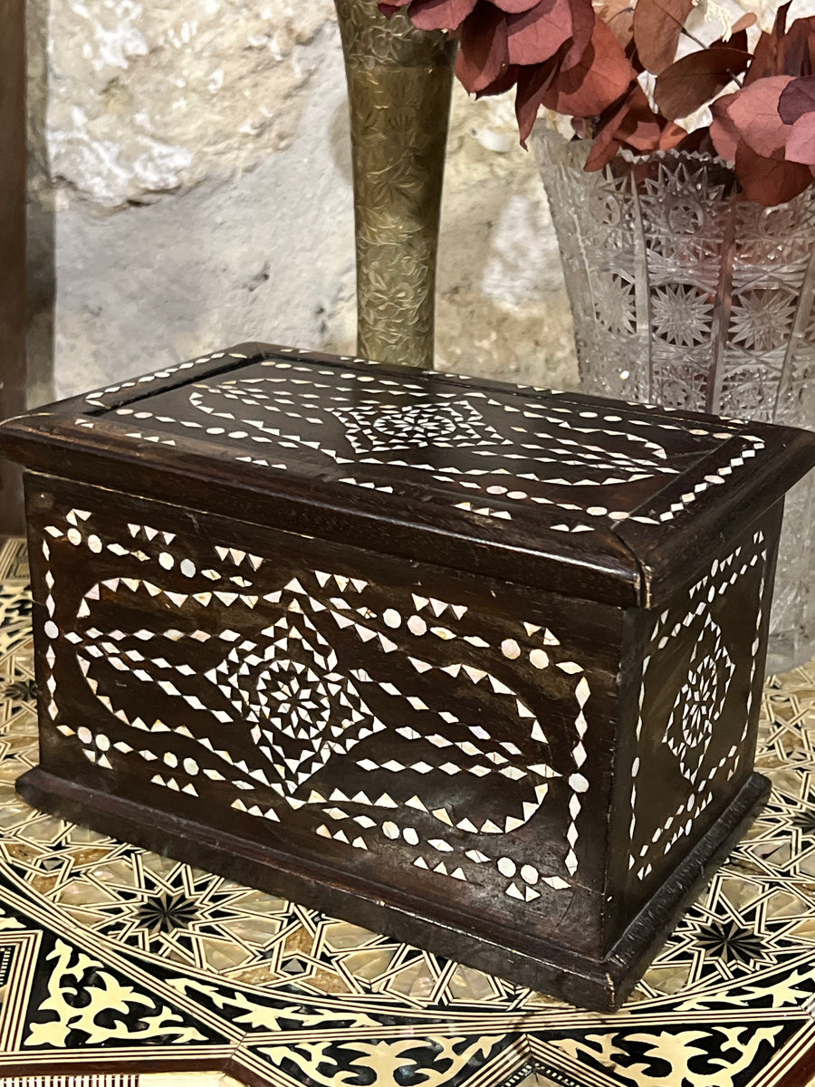 Bauletto orientale in legno impreziosito da intarsi geometrici in madreperla, che creano un effetto decorativo unico. Dotato di un pratico coperchio scorrevole, questo oggetto è ideale come contenitore per piccoli oggetti, gioielli o come pezzo d’arredo dal fascino esotico.

Misure 21x13,5x13,5 cm