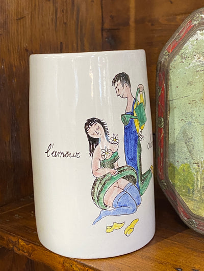 Boccale in ceramica della manifattura "Il cardo d'oro" attiva tra il 1947 e il 1958" a Firenze. Vi è raffigurata una rappresentazione del "Amore campestre" scritto in francese. Facente parte di una serie sulle varie forme dell'amore in vendita nel nostro negozio.  Misure 14x15x9 cm