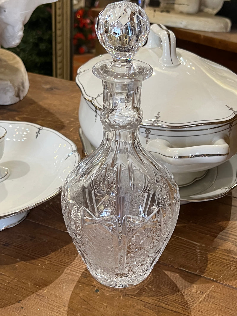 Bottiglia in cristallo con decoro intagliato e tappo a sfera.