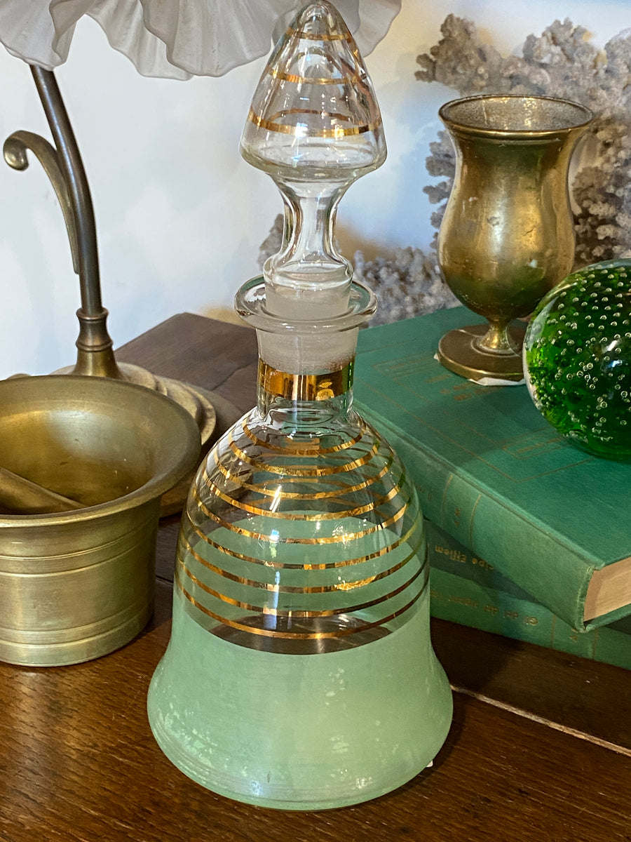 Bottiglia da rosolio in vetro con dettagli dorati e verde.