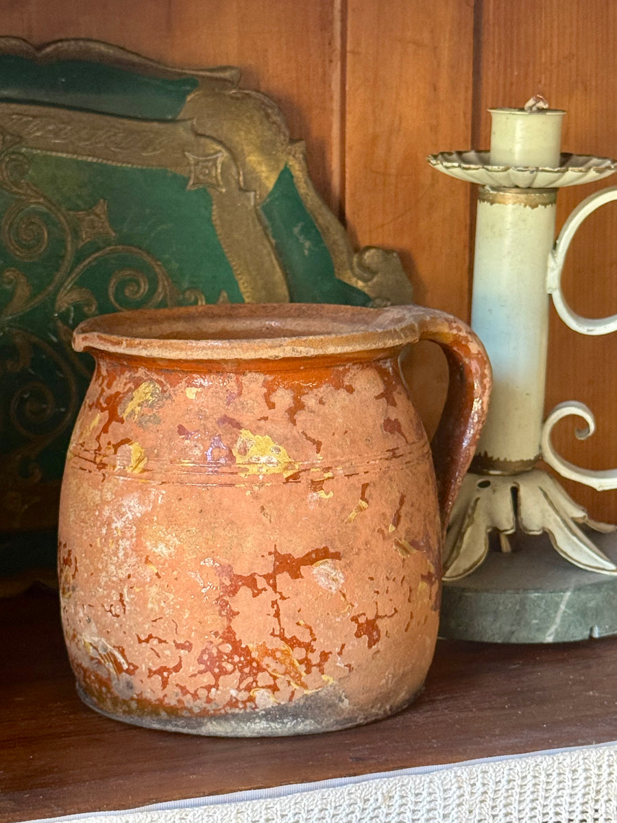 Brocca antica in terracotta smaltata con patina rustica e manico laterale.