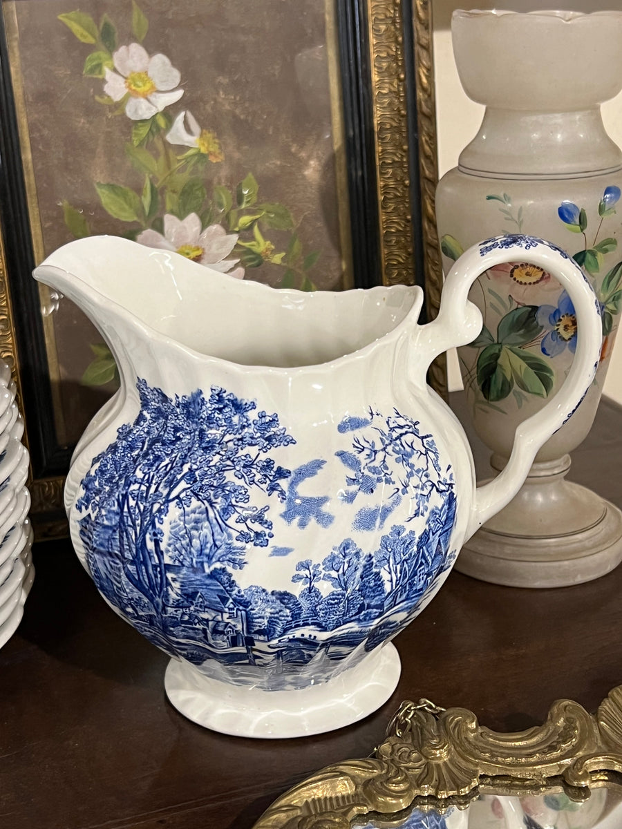 Brocca in ceramica inglese firmata Johnson Bros con decorazione case di campagna sui toni del blu.

Le sue linee e il suo decoro lo rendo un'elemento decorativo di grande eleganza.

Misure 17,5x16,5x14 cm