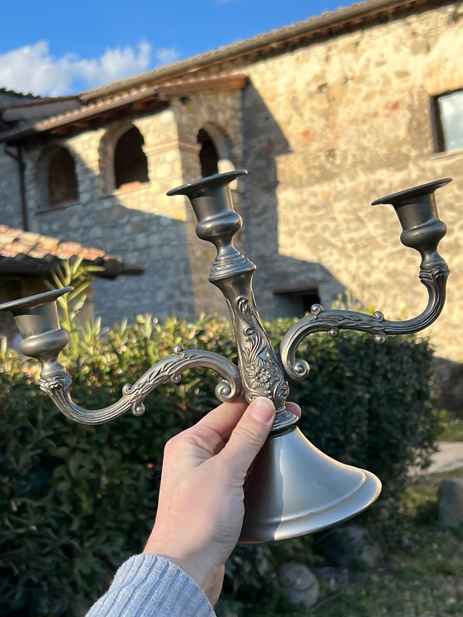 Elegante candelabro a tre braccia in metallo, perfetto per aggiungere un tocco di charme senza tempo alla tua casa. Con le sue linee fluide e i dettagli floreali finemente decorati richiamano lo stile classico, è ideale per creare un'atmosfera calda e accogliente.

Misure 31x12x23 cm
