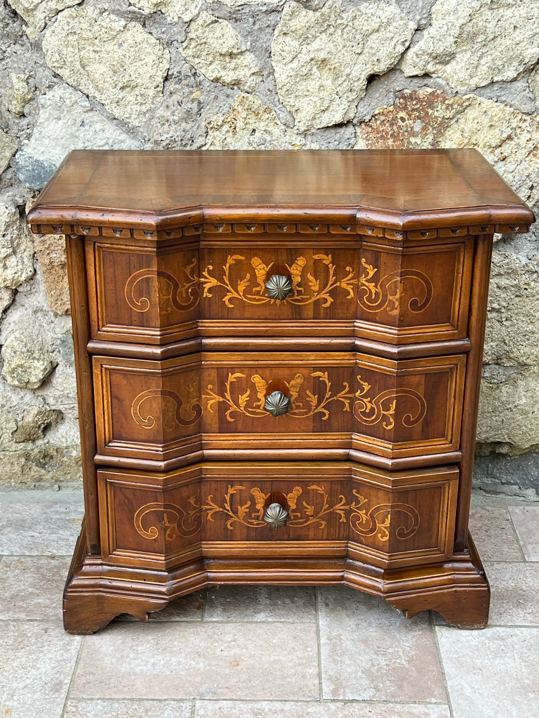 Elegante Cassettiera di ridotte misure in legno pregiato con raffinati intarsi floreali e decorazioni a motivi classici. La struttura a tre cassetti offre ampio spazio per riporre oggetti e le maniglie in metallo lavorato donano ulteriore fascino a questo mobile.

Misure 63x37x64 cm