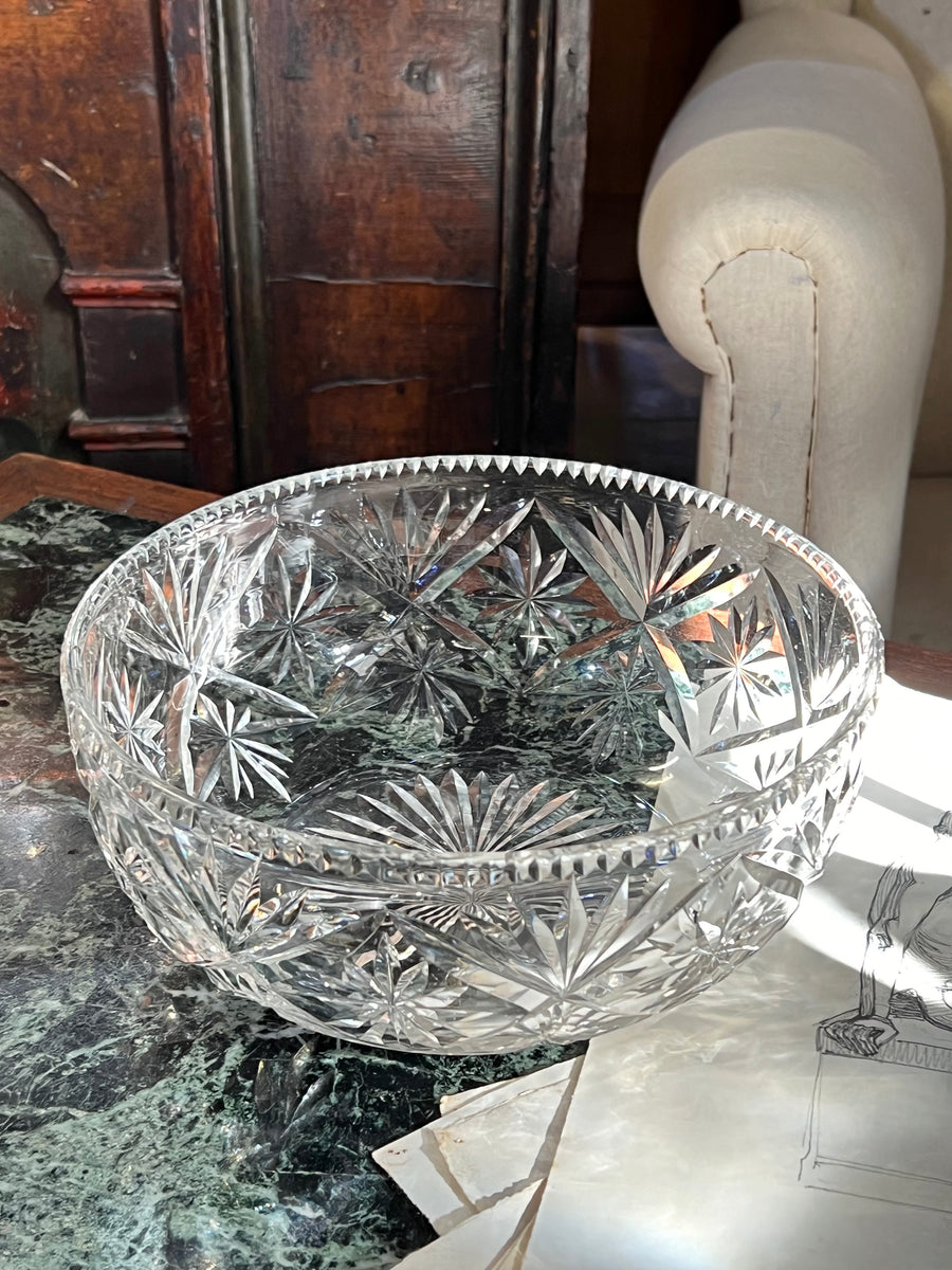 Ciotola in cristallo molato con motivo a stella e bordo smerlato, su tavolo in marmo