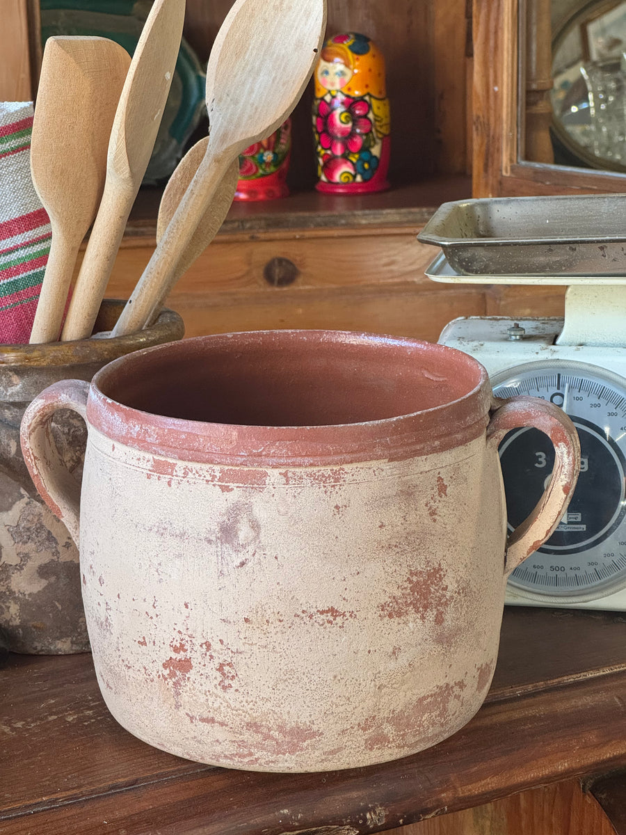 Contenitore rustico vintage in terracotta con due manici, superficie beige consumata e terracotta rossa a vista.