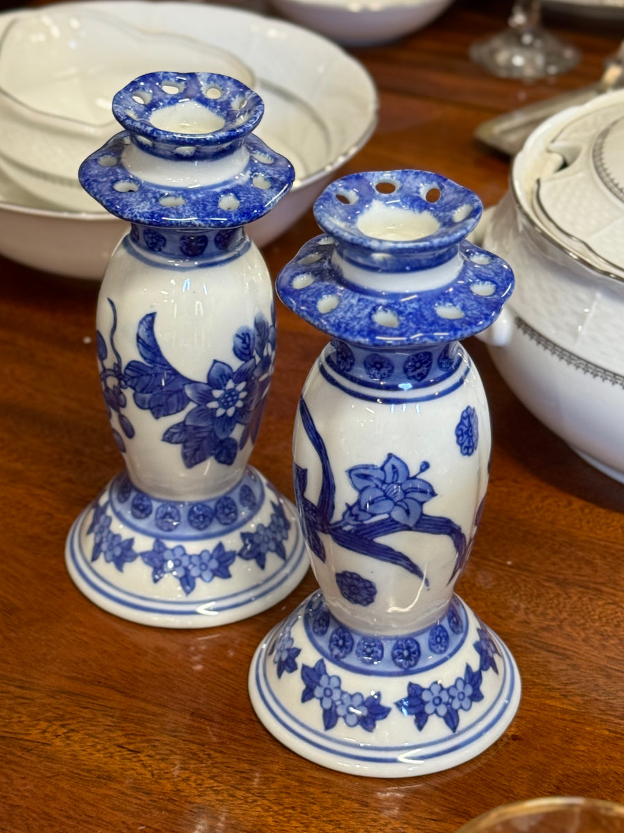 Coppia di portacandele in porcellana bianca decorata in blu con motivi floreali di ispirazione orientale.