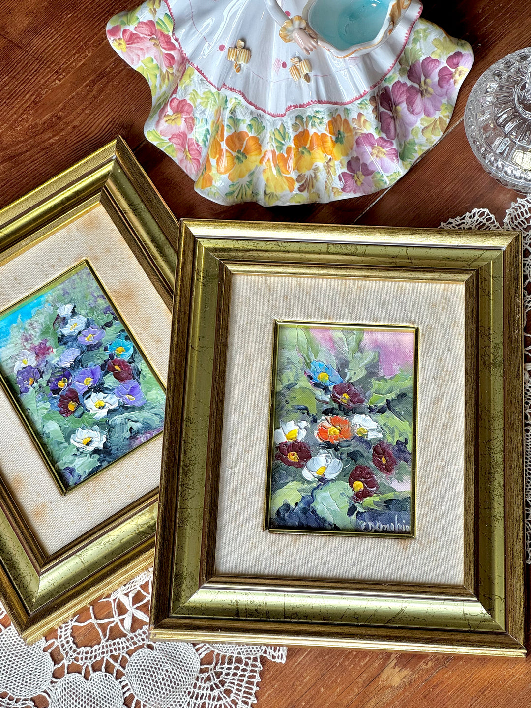 Coppia di piccoli dipinti a olio su tela con viole e fiori multicolore, inseriti in cornici dorate con passe-partout