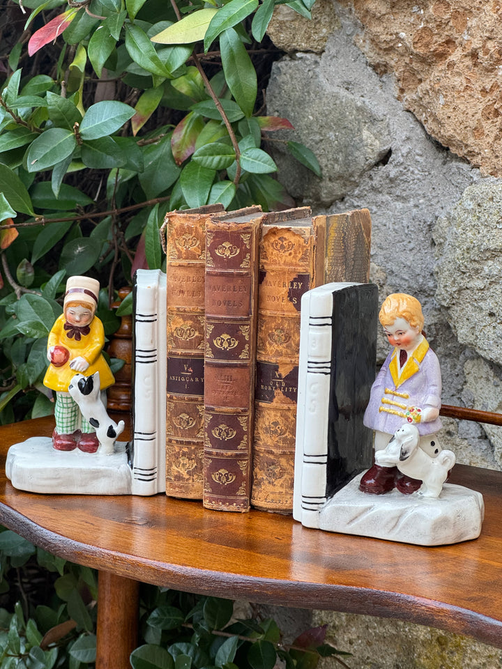 Coppia di fermalibri vintage in porcellana dipinta con bambini e cagnolini