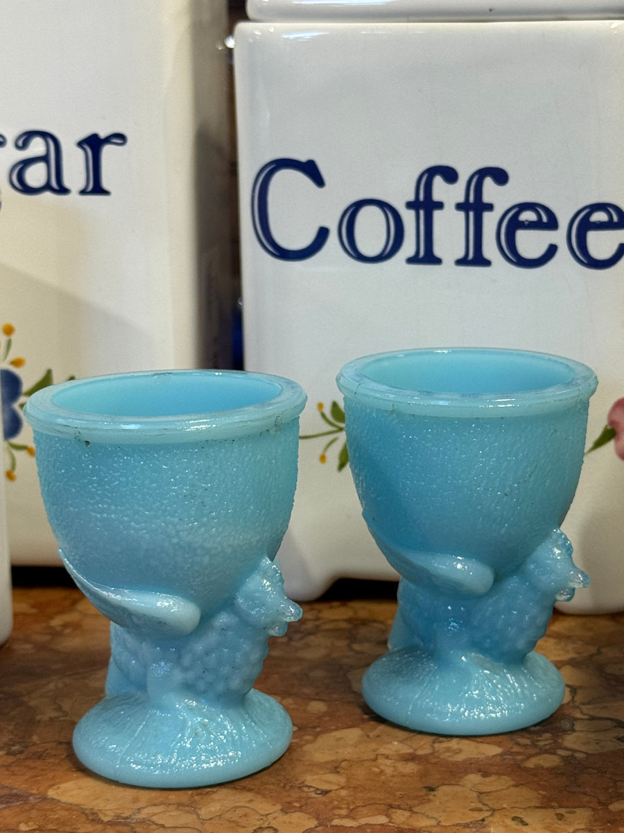 Coppia di portauovo in vetro opalino azzurro con gallina in rilievo