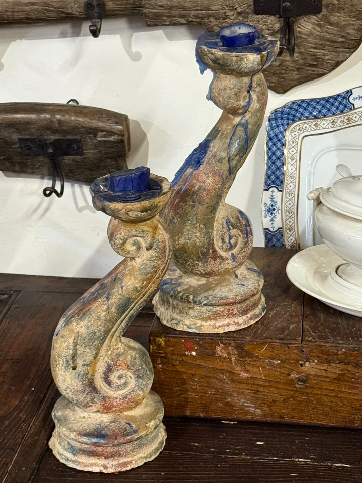 Coppia di candelieri barocchi in terracotta policroma con finitura anticata e decorazione a voluta