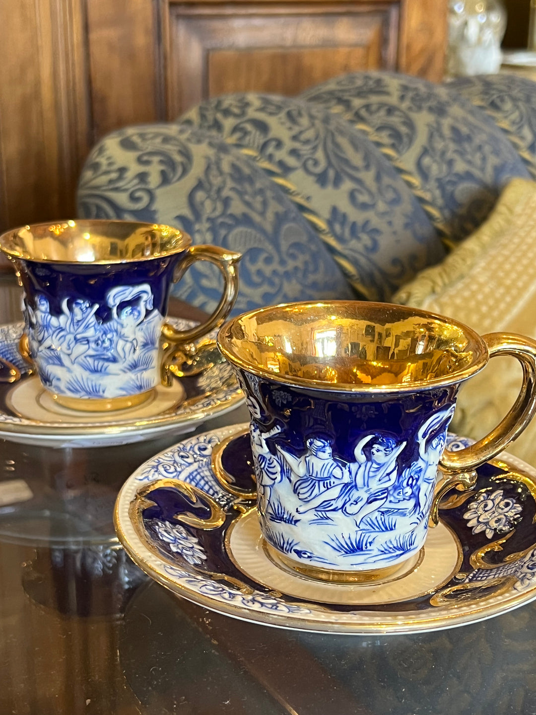 Coppia di tazzine Capodimonte in porcellana blu cobalto con scena in rilievo e interno dorato