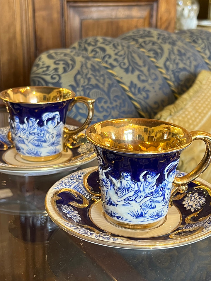 Coppia di tazzine Capodimonte in porcellana blu cobalto con scena in rilievo e interno dorato