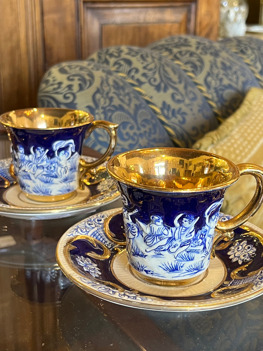 Coppia di tazzine Capodimonte in porcellana blu cobalto con scena in rilievo e interno dorato