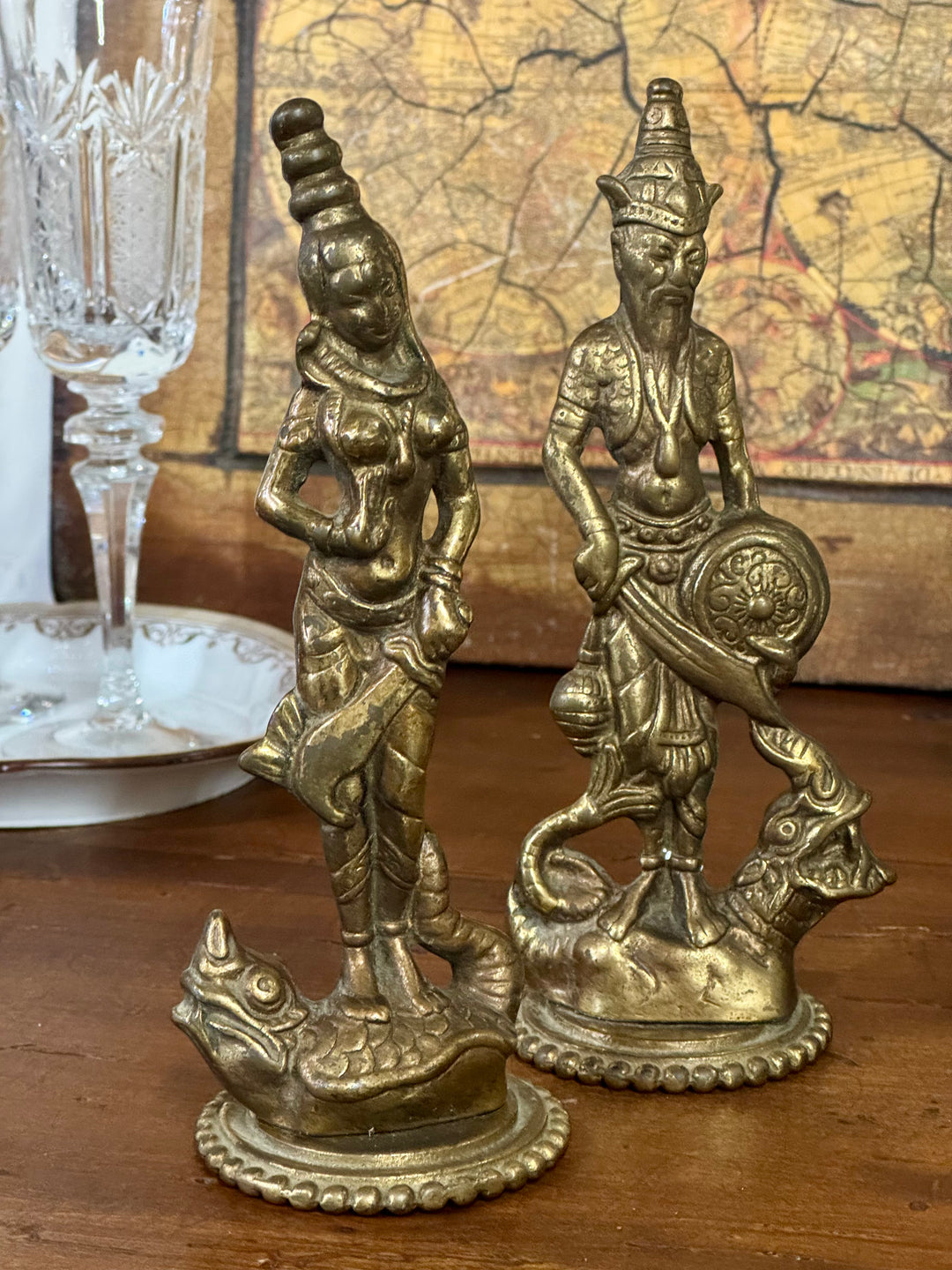 Coppia di statue balinesi in ottone dorato raffiguranti figura femminile e guerriero con scudo