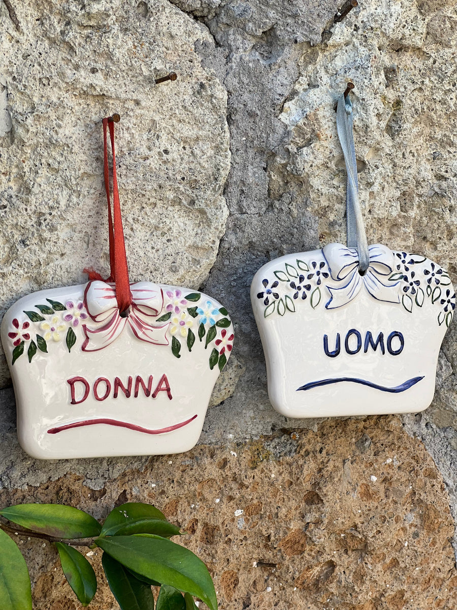 Coppia di targhette vintage in porcellana con scritte Donna e Uomo, fiocchi in rilievo e motivi floreali