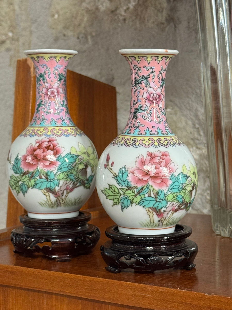 Coppia di vasi in porcellana cinese decorati a mano con motivi floreali rosa e basi in legno intagliato