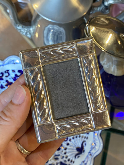 Cornice portafoto in argento con decoro.