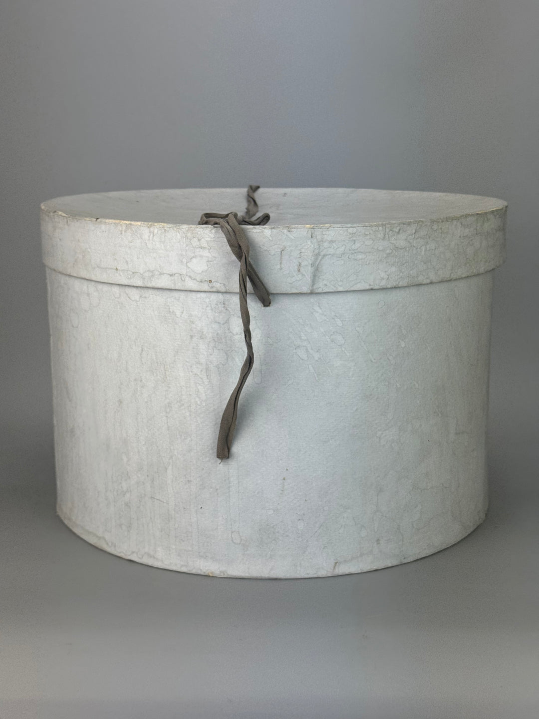 Cappelliera Vintage rotonda in cartone di colore grigio con chiusura a nastro
