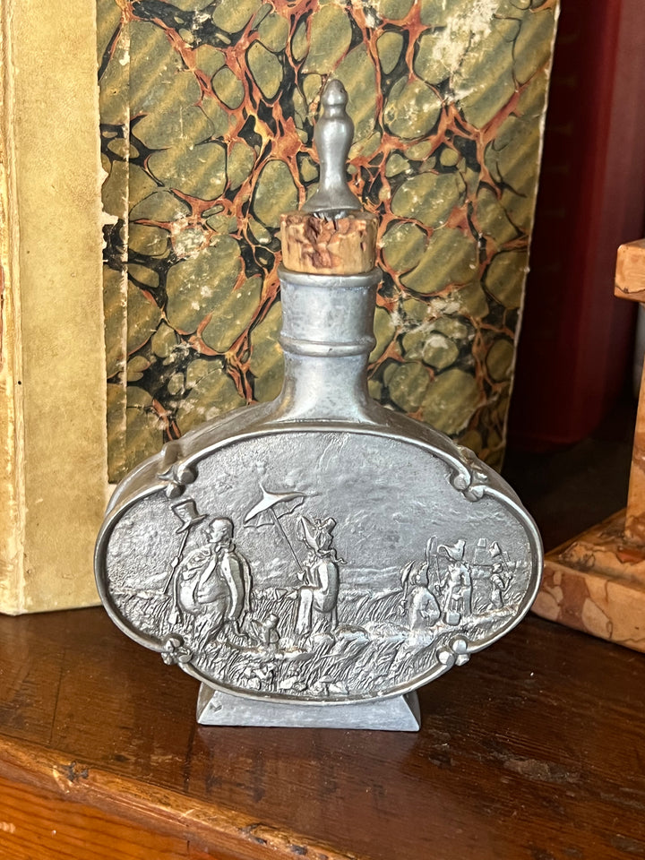 Fiaschetta ovale in peltro con decorazione in rilievo raffigurante scena di contadini