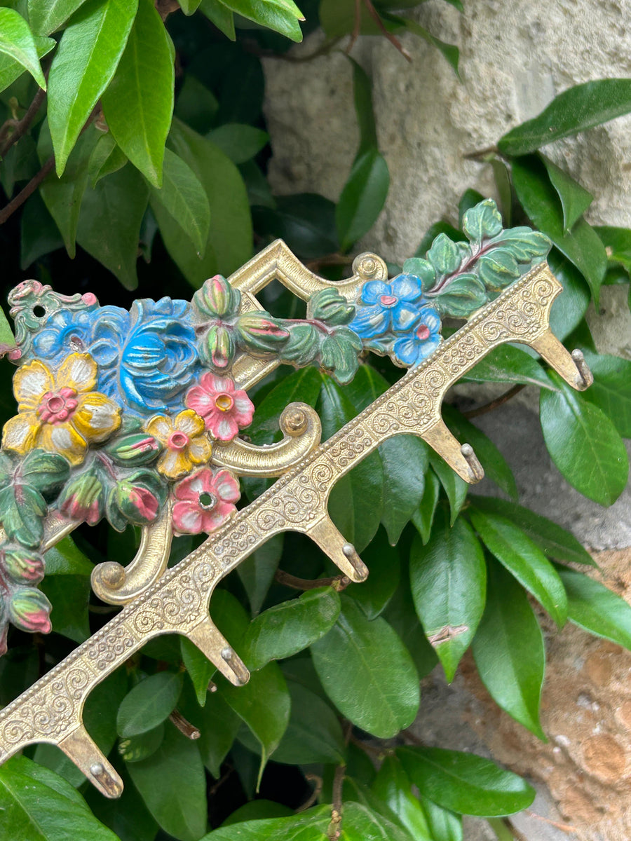 Gancio portachiavi in metallo dorato con delizioso decoro floreale variopinto. Questo pezzo non solo è pratico per appendere chiavi e accessori ma aggiunge un tocco di eleganza essendo una deliziosa decorazione murale.&nbsp;

Misure 23x12 cm