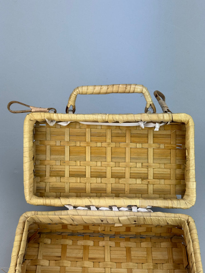 Valigetta vintage in vimini intrecciato con manici e chiusure decorative