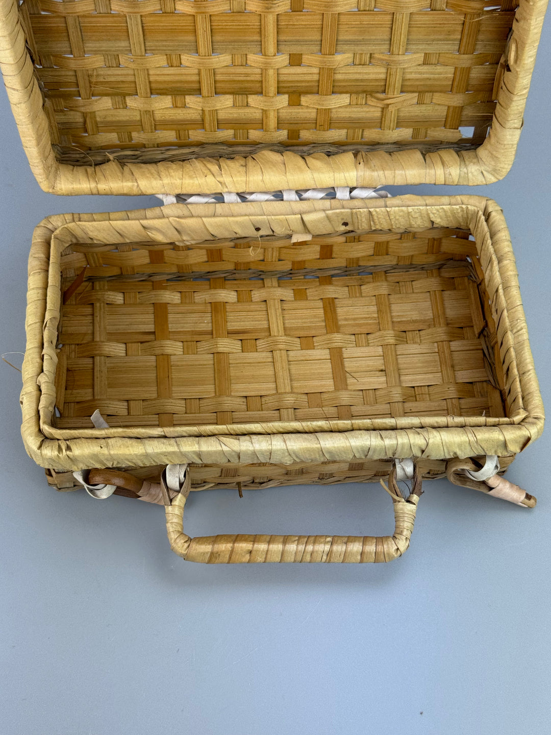 Valigetta vintage in vimini intrecciato con manici e chiusure decorative