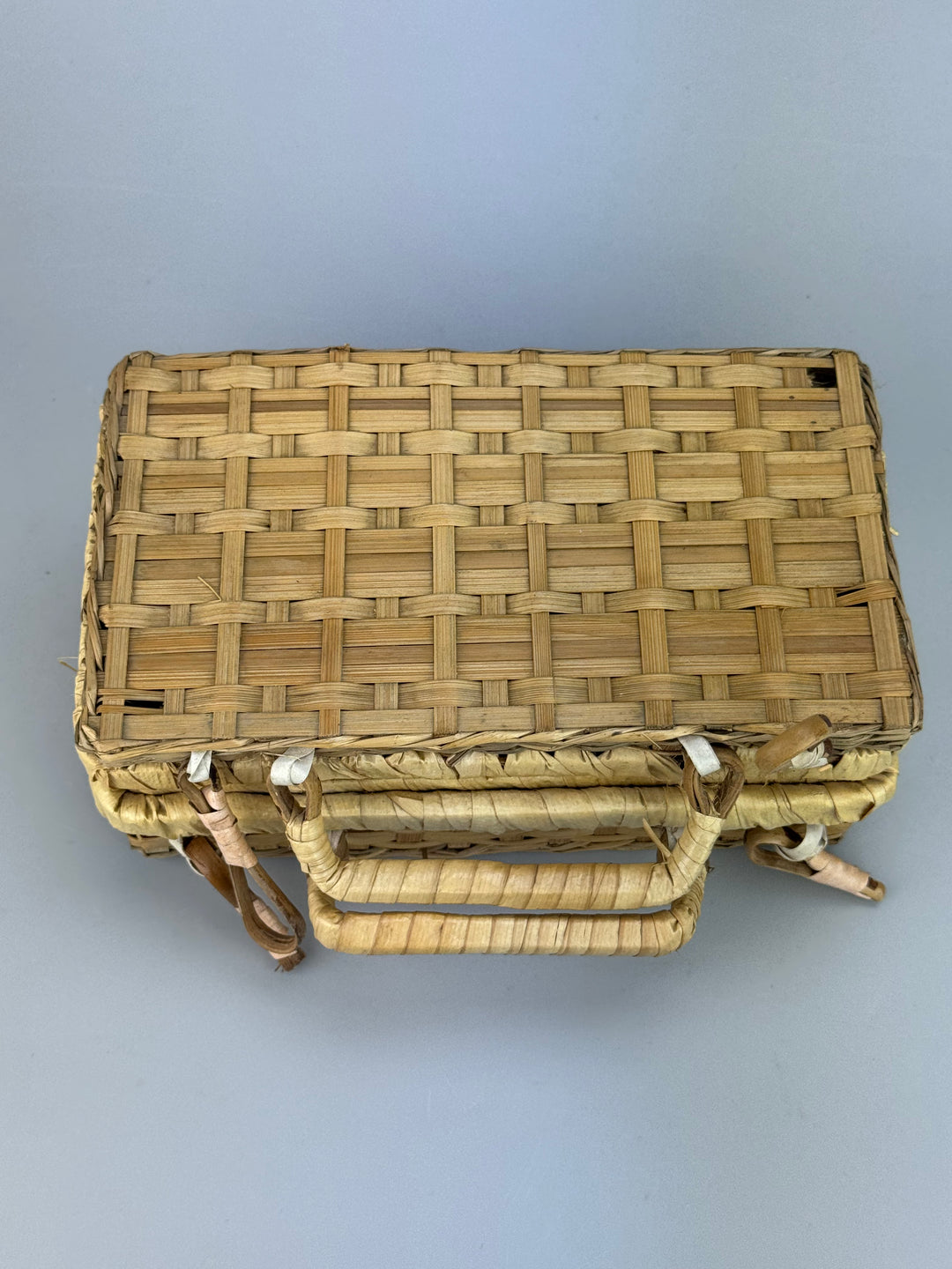Valigetta vintage in vimini intrecciato con manici e chiusure decorative