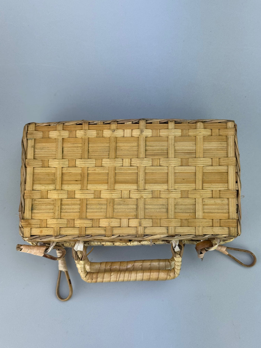 Valigetta vintage in vimini intrecciato con manici e chiusure decorative