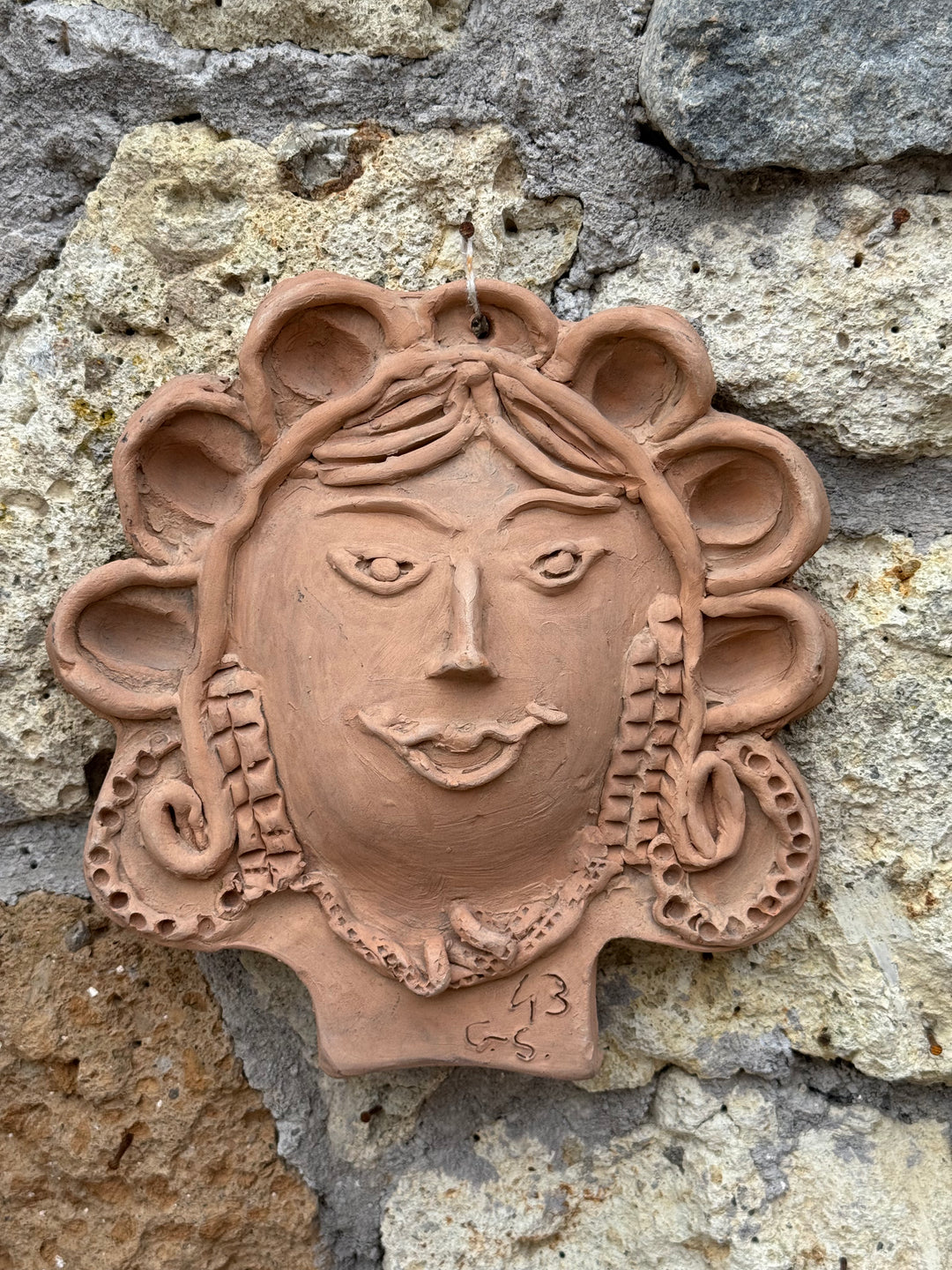 Decorazione da parete in terracotta con volto femminile