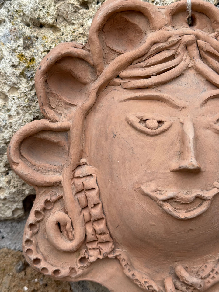 Decorazione da parete in terracotta con volto femminile