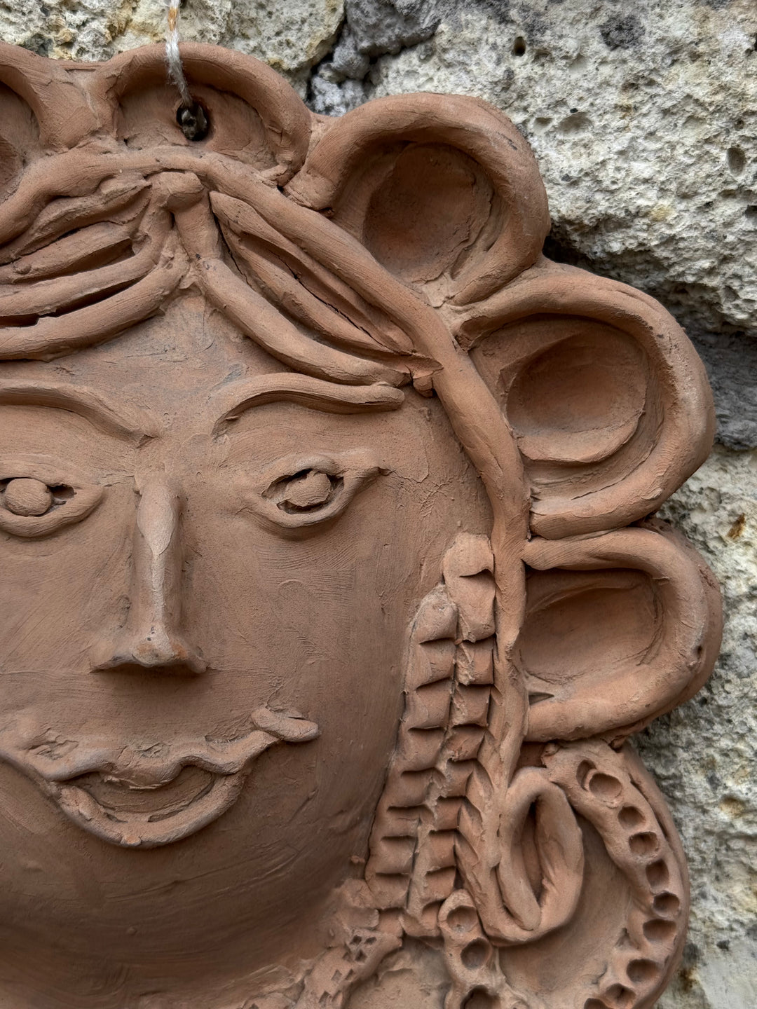 Decorazione da parete in terracotta con volto femminile