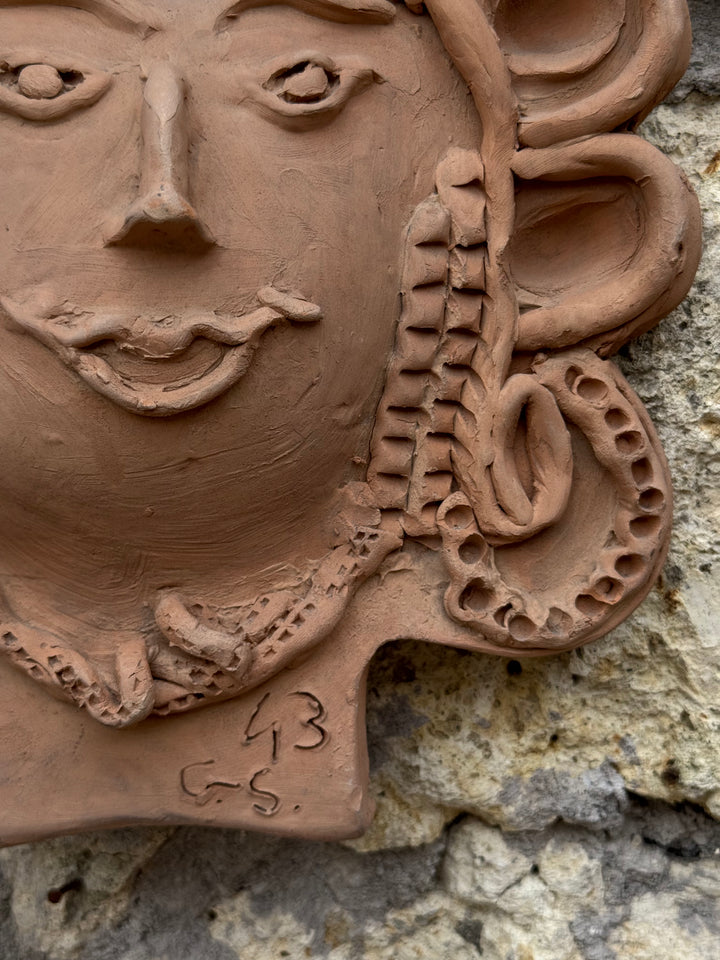 Decorazione da parete in terracotta con volto femminile