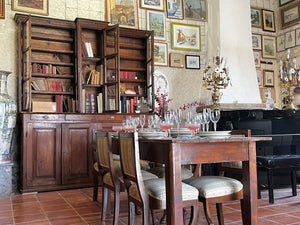 Ingresso del negozio vintage: un pianoforte giapponese kawai , una grande biblioteca francese in rovere ed un tavolo apparecchiato elegantemente con un servizio di bicchieri in cristallo vintage e dei piatti ginori. sulle pareti quadri e stampe d'epoca