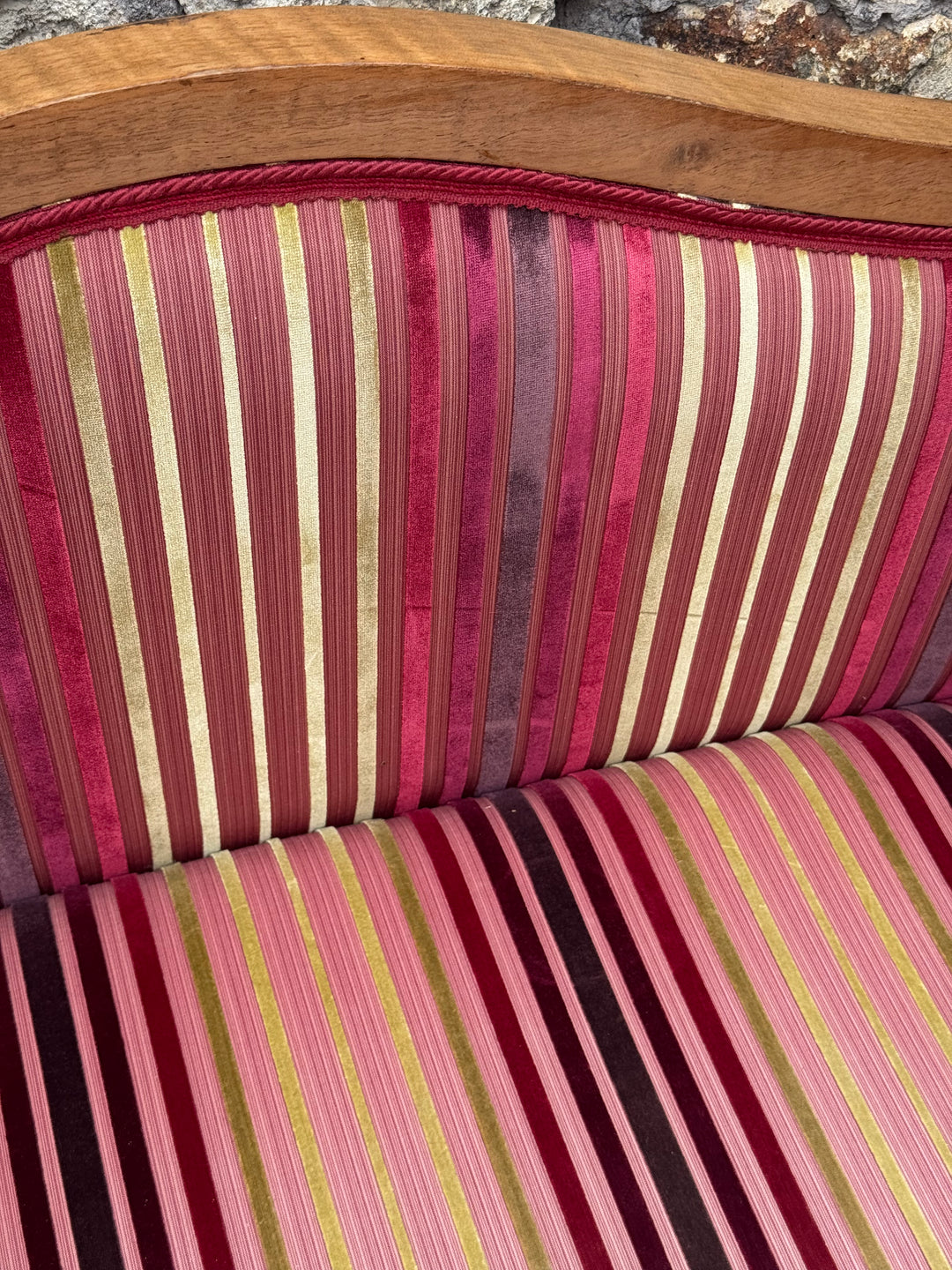 Divanetto stile Carlo X in legno con rivestimento a righe nei toni del bordeaux e rosa