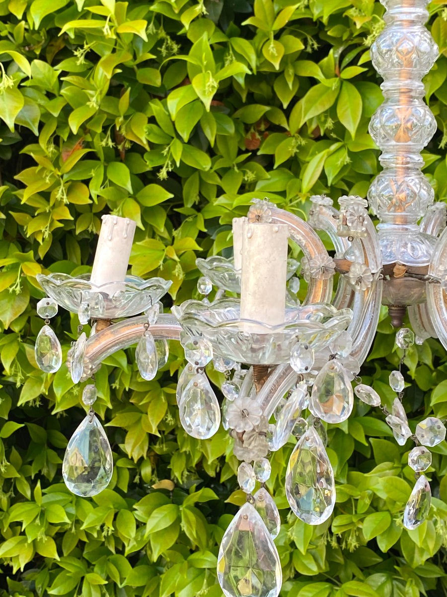 Lampadario a sei braccia in vetro stile Maria Teresa con gocce e profili dorati.&nbsp;  Dal carattere elegante e classico, è l'elemento d'arredo perfetto per illuminare con grazia qualsiasi ambiente.  Presente catena regolabile per appenderlo.  Misure 49x50h cm lunghezza braccia 23 cm&nbsp;