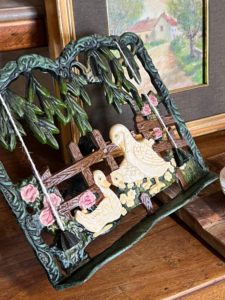 Leggio vintage in ghisa decorata con scena di papere accanto a staccionata e rose