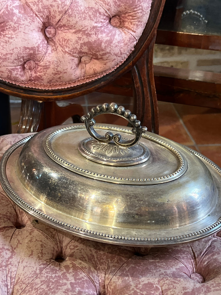 Legumiera in argento placcato caratterizzato da un elegante manico decorativo e un bordo finemente lavorato, esempio eccellente di artigianato classico. Nonostante i segni del tempo che ne testimoniano la storia, il vassoio mantiene tutto il suo fascino e la sua funzionalità.

Misure 30x22 cm