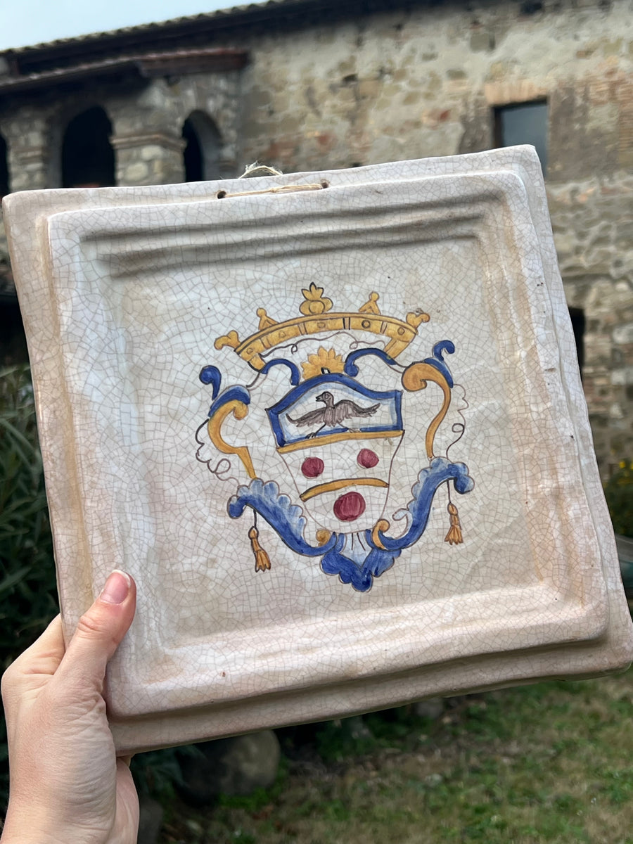 Mattonella decorativa da parete in ceramica smaltata con stemma dipinto a mano. La superficie presenta un effetto craquelé che esalta il carattere vintage e aggiunge un tocco di autenticità.

Misure 27x29 cm&nbsp;