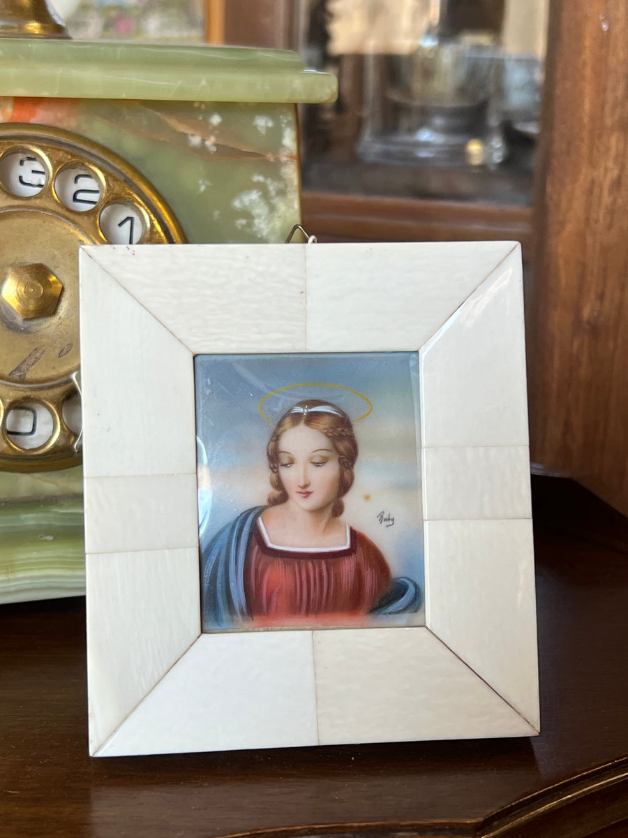 <p>Miniatura femminile raffigurante la Madonna del Cardellino dipinto a mano da Ruby dei primi del novecento. Posta all'interno di una cornice (da parete e da appoggio) in avoriolina.</p> <p>Misure 10,5x10,5 cm</p>