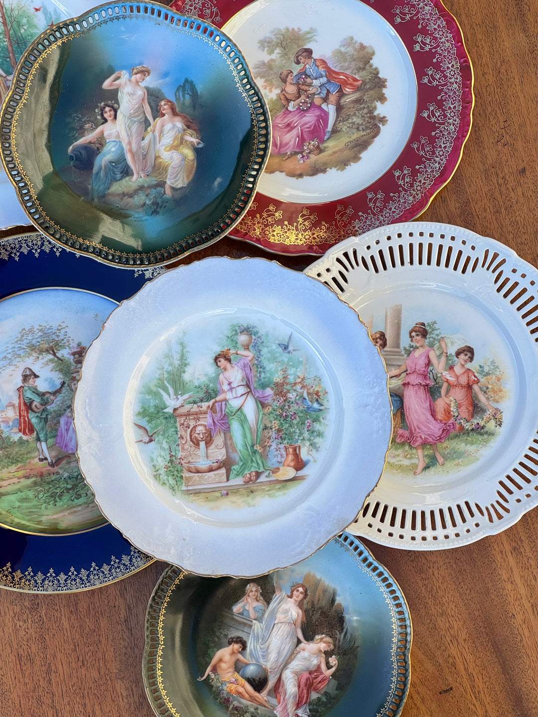 Collezione di piatti decorativi in porcellana con scene romantiche e bordi dorati